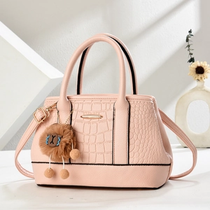 Rosa Handtasche mit Krokodil-Prägung, goldenem Verschluss und flauschigem Anhänger