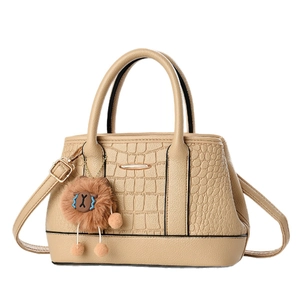 Beige Handtasche mit Krokodilprägung, Plüsch-Löwenanhänger und abnehmbarem Gurt
