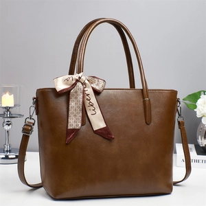 Brown leather tote bag with decorative silk scarf and adjustable strap for women