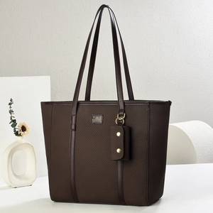 Detail of dark brown woven tote bag with metallic logo and detachable small pouch