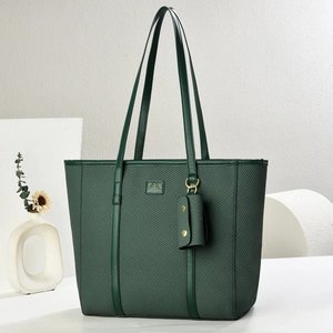 Dark green woven tote bag with matching coin purse and gold metal hardware for women