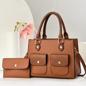 Détail du sac à main marron en cuir grainé avec poches à boucle dorée et petit portefeuille assorti