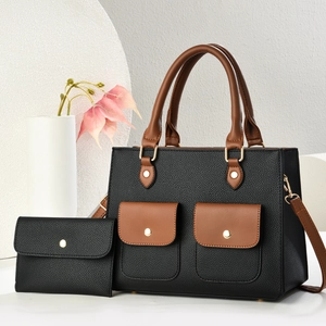 Détail du sac cabas bicolore en cuir grainé avec des finitions métalliques dorées