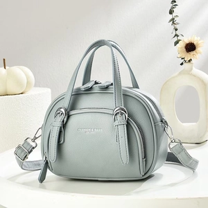 Blue-grey pebbled leather handbag with crossbody strap and front zipper pocket detail
