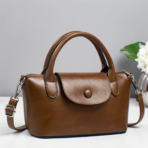 Sac à main rétro en cuir marron avec poignée et bandoulière dans un décor élégant