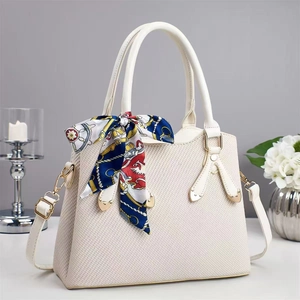 Detail of off-white handbag with twill weave texture and elegant decorative silk scarf
