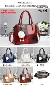 Detail view of glossy crocodile-embossed leather handbags with white fur ball charm