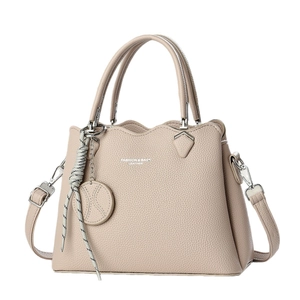 Beige lychee leather handbag with wavy top edge and adjustable crossbody strap