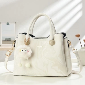 Chic beige marble pattern handbag with plush charm and adjustable shoulder strap