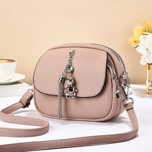 Chic pink leather shoulder bag with multi-zip compartments and silver bear pendant