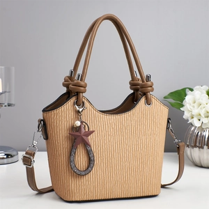 Vue détaillée du sac seau beige texturé avec pendentif étoile et poignées marron foncé
