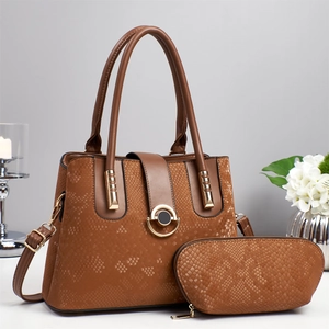 Large brown snakeskin tote bag with matching pouch and gold hardware on grey background