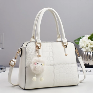 White faux crocodile skin handbag for women with gold hardware and plush ball charm