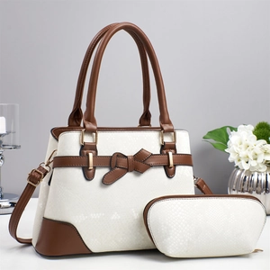 Close-up of white snakeskin pattern tote bag with brown leather trim and gold hardware