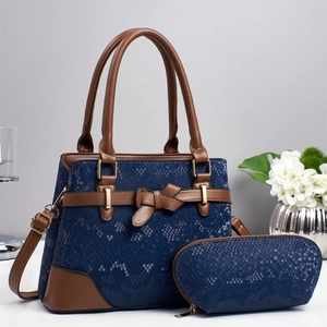 Detail of blue snakeskin tote with brown trim, gold hardware and matching pouch