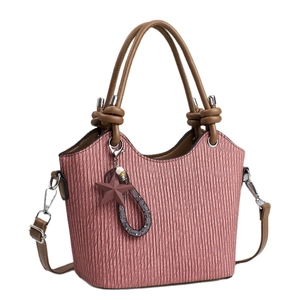 Sac seau rose à texture plissée avec poignées marron et breloque étoile sur fond blanc