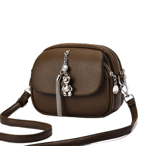 Brown leather crossbody bag with three zipper layers and silver bear pendant
