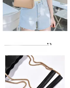Detail of elegant woven metal gold chain and leather handle on a chic crossbody bag