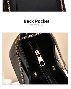 Detail of black leather shoulder bag showing back pocket and gold chain strap