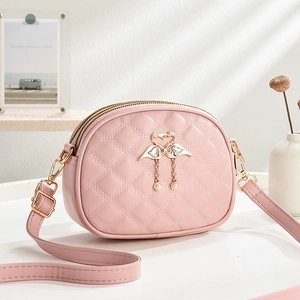 Pink quilted crossbody bag with heart flamingo emblem and triple zipper design
