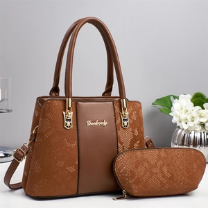 Detail of a brown snakeskin pattern tote bag with gold logo and matching pouch set
