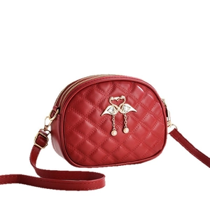 Red quilted leather crossbody bag with golden swan charm and adjustable shoulder strap