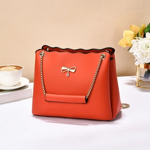 Fashionable orange crossbody bag for women with gold bow and elegant wave edges