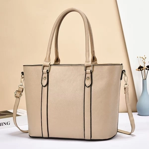 Minimalist beige pebble leather tote bag with shoulder strap in a stylish still life setting