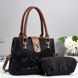 Detailed view of black snakeskin patterned two-piece handbag set with gold clasp