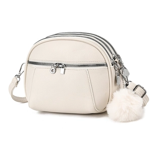 Off-white multi-layered crossbody bag with zipper compartments and fur ball charm