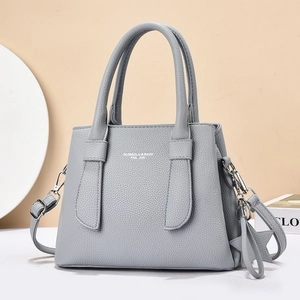 Minimalist light gray lychee grain leather tote bag with a modern shoulder strap design
