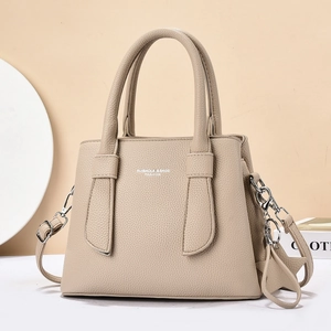 Close-up of beige lychee grain leather handbag with silver hardware and dual handles