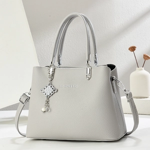 Light gray pebbled leather tote bag with silver hardware and chic tassel pendant