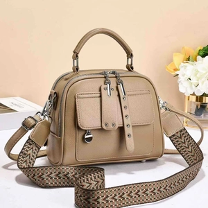 Khaki crossbody bag with textured leather and geometric wide strap on a stylish background