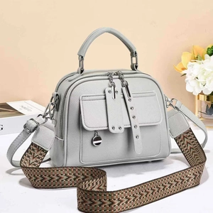 Grey soft leather handbag with dual zippers and a patterned embroidery shoulder strap