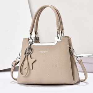 Détail du sac à main beige grainé avec finitions argentées et pendentif en étoile
