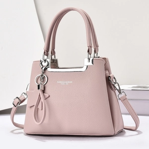 Vue détaillée du sac à main rose en cuir grainé avec logo argenté et breloque en étoile