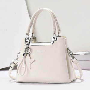 Détail du sac cabas crème texture lychee avec pendentif étoile argenté et ferrures en métal