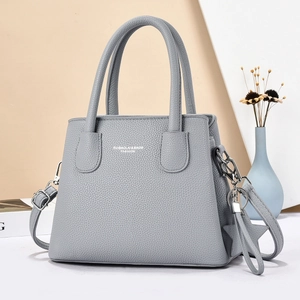 Elegant grey lychee leather handbag with star pendant and adjustable crossbody strap