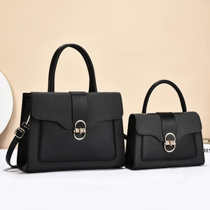 Elegant black leather handbag set with gold oval twist lock and woven texture detail
