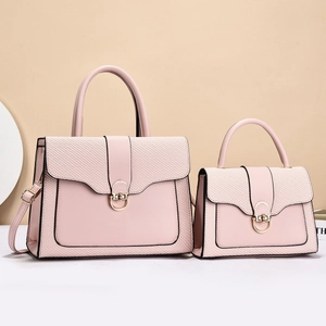 Detail of light pink shoulder bags with golden metal buckle and textured woven fabric