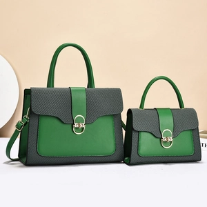 Detail of emerald green and gray patchwork handbag set with golden oval swivel lock