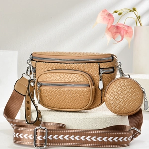 Detail of khaki crossbody bag with textured leather, wide patterned strap and coin purse