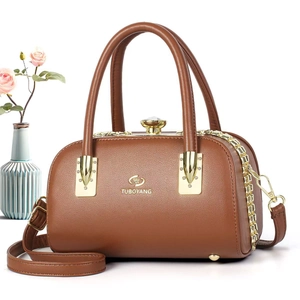 Détail d'un sac Boston en cuir marron avec fermoir en cristal et bandoulière réglable