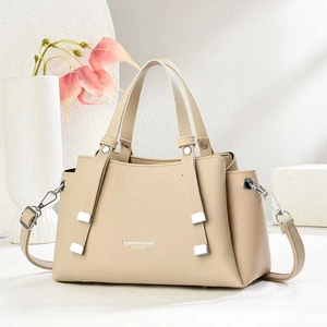 Detail view of cream-colored lychee pattern leather bag with silver metal hardware and strap