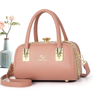 Détail du sac à main rose en similicuir avec garnitures dorées et bandoulière