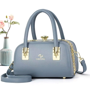 Détail du sac Boston en cuir bleu-gris avec fermoir cristal et finitions dorées