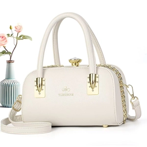 Détail du sac Boston blanc crème avec fermoir en strass et accents métalliques dorés