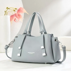 Detail of light blue lychee pattern leather bag with silver hardware and shoulder strap