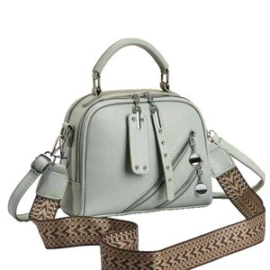Pale green pebble leather handbag with patterned wide strap and multiple zippers